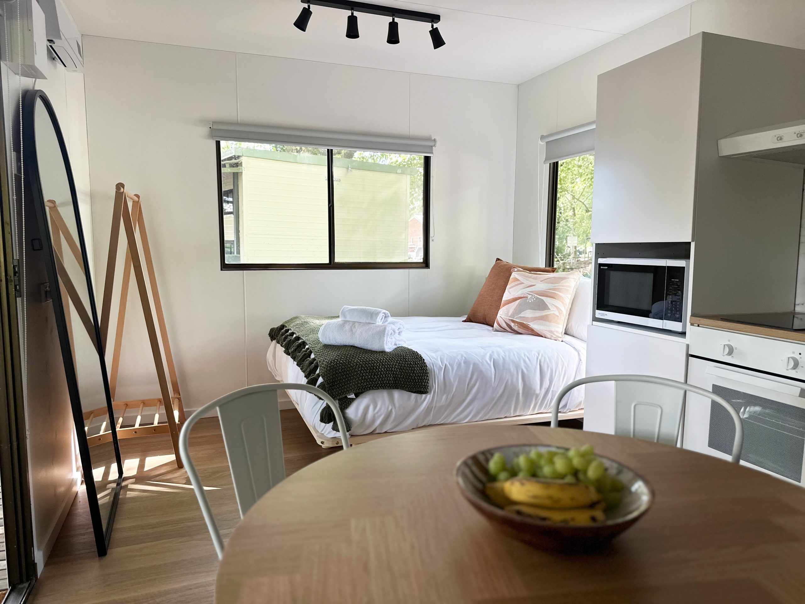 tawonga tourist park inside cabin with bedroom next to kitchen and dining room